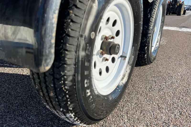 Slide: The Image of Close-up of a 2010 Chaparral 216 SSi trailer wheel on asphalt road. - 28