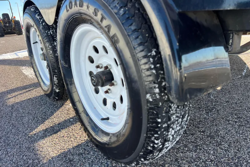 Slide: The Image of Trailer wheels for 2010 Chaparral 216 SSi boat on asphalt surface. - 29