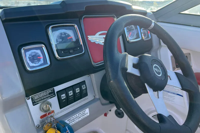 Slide: The Image of Steering wheel and dashboard of 2010 Chaparral 216 SSi boat, featuring gauges and controls. - 36