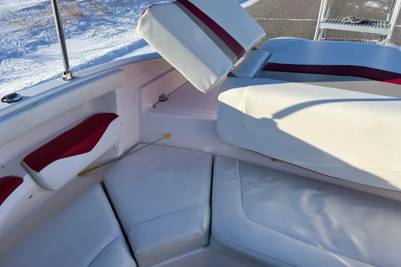 Slide: The Image of 2010 Chaparral 216 SSi boat interior with white and red seating, snowy background. - 39
