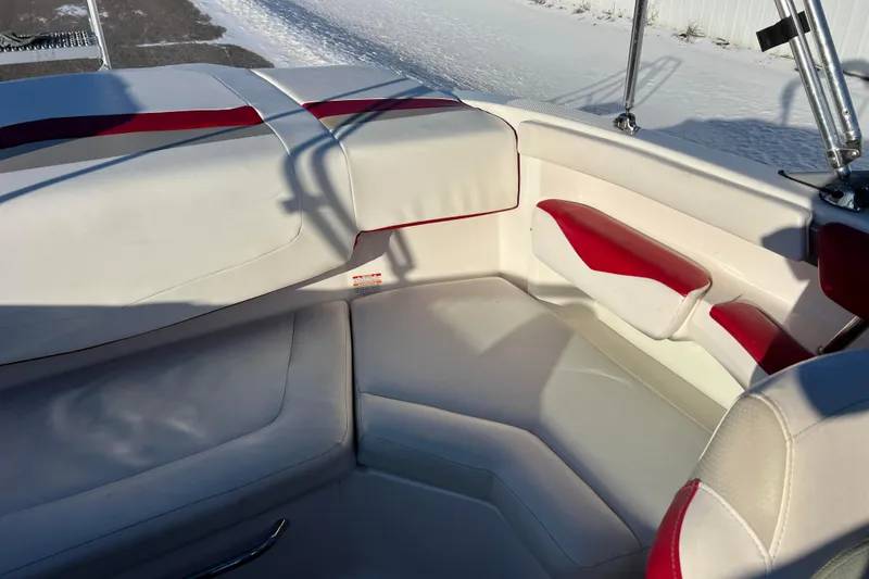 Slide: The Image of 2010 Chaparral 216 SSi boat interior with white and red seating, snowy background. - 40