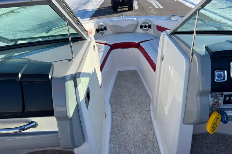 Slide: The Image of 2010 Chaparral 216 SSi boat interior with red and white seating, dashboard, and controls. - 43