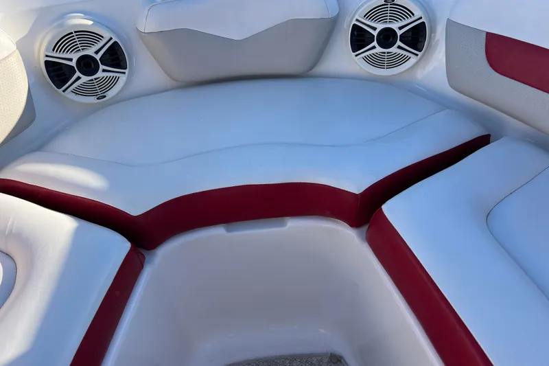 Slide: The Image of 2010 Chaparral 216 SSi boat interior with red and white seating and speakers. - 46