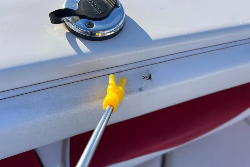 Slide: The Image of 2010 Chaparral 216 SSi boat with a yellow tool pointing at a scratch. - 50