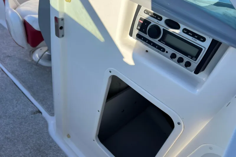 Slide: The Image of 2010 Chaparral 216 SSi boat interior with stereo system and storage compartment. - 60