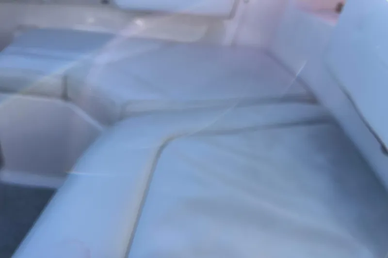 Slide: The Image of Interior seating of a 2010 Chaparral 216 SSi boat, featuring white cushioned seats. - 63