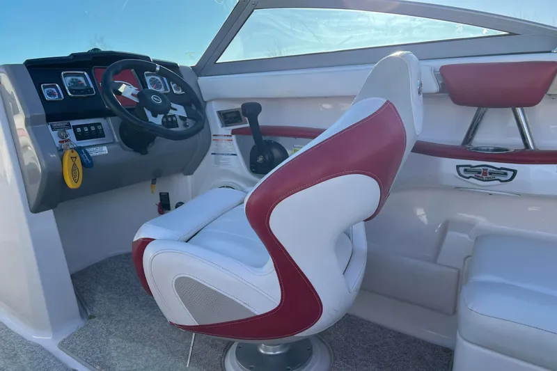 Slide: The Image of 2010 Chaparral 216 SSi boat interior with red and white captain's seat and dashboard. - 64