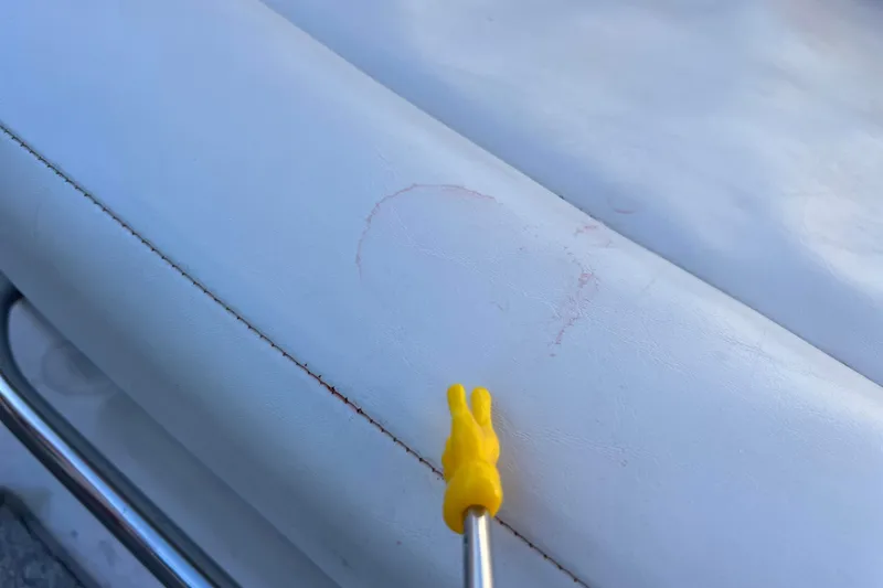 Slide: The Image of White leather seat with a yellow tool on a 2010 Chaparral 216 SSi boat. - 71