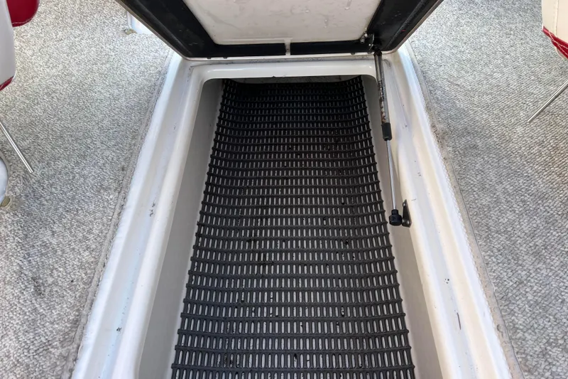 Slide: The Image of Open storage compartment in 2010 Chaparral 216 SSi boat with black matting. - 74