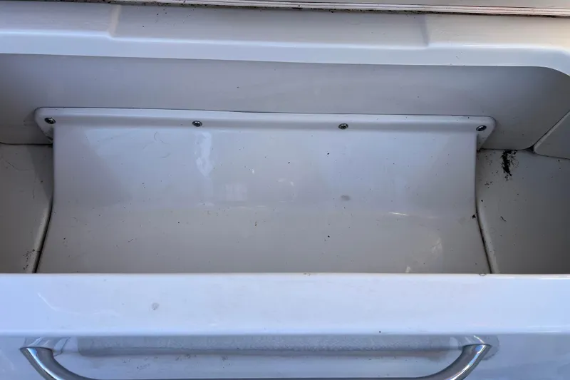 Slide: The Image of Storage compartment of 2010 Chaparral 216 SSi boat, featuring a clean, white interior. - 76