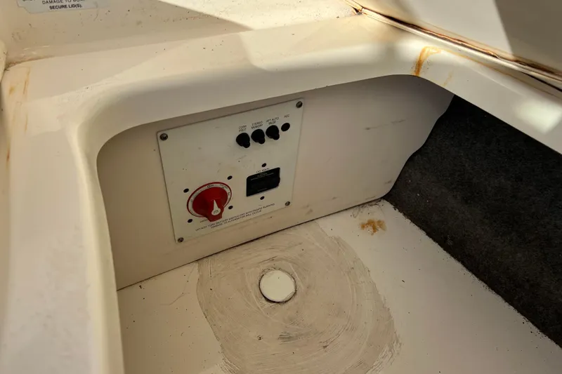 Slide: The Image of Control panel of a 2010 Chaparral 216 SSi boat, featuring switches and a red dial. - 77