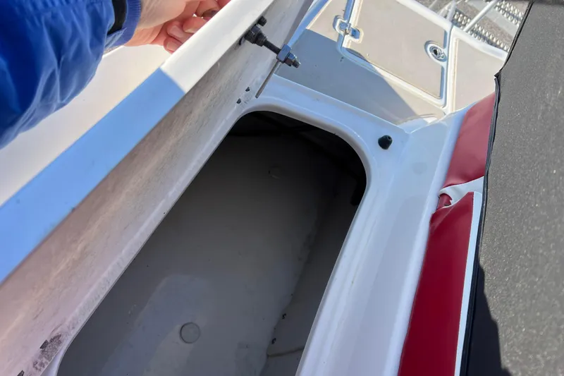 Slide: The Image of 2010 Chaparral 216 SSi boat storage compartment with red and white interior details. - 79
