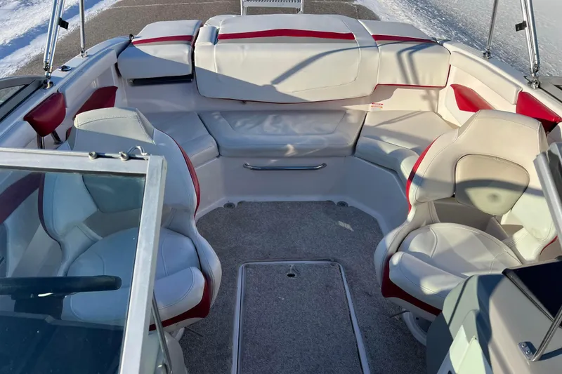 Slide: The Image of 2010 Chaparral 216 SSi boat interior with white and red seating, snowy background. - 81