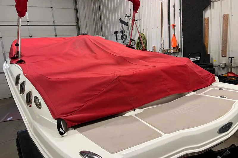 Slide: The Image of 2010 Chaparral 216 SSi boat with red cover in a garage setting. - 88