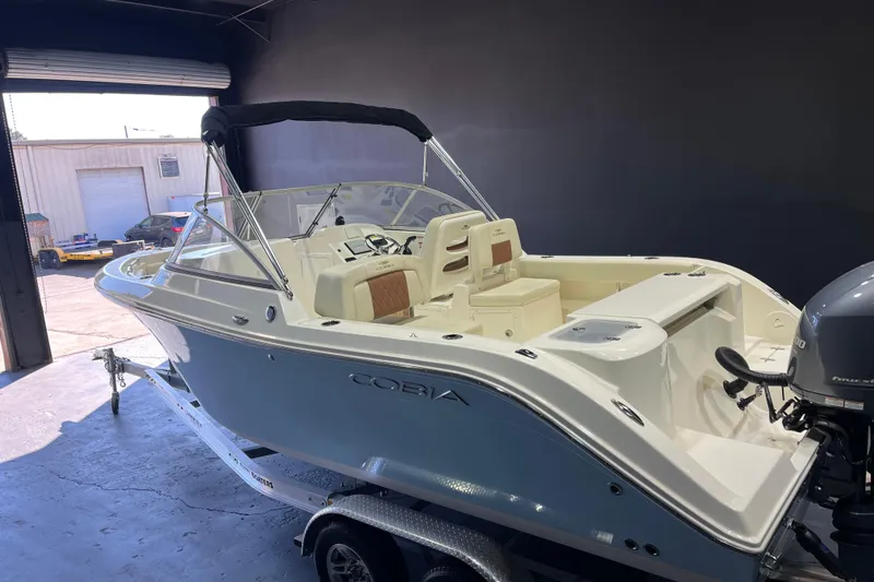 Slide: The Image of 2023 Cobia 220 Dual Console boat in a garage, showcasing sleek design and modern features. - 14