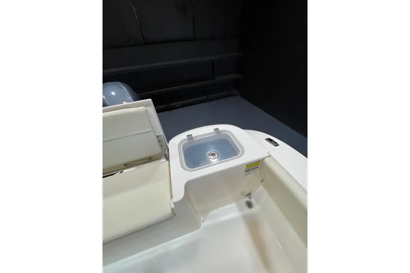Slide: The Image of 2023 Cobia 220 Dual Console boat interior with storage compartment and seating area. - 17