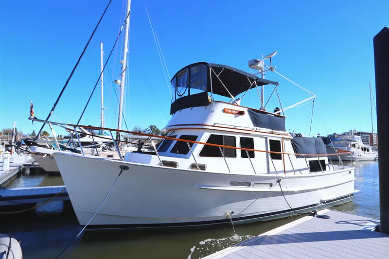 The Image of 2005 Monk 36 yacht docked at marina under clear blue sky. - 0