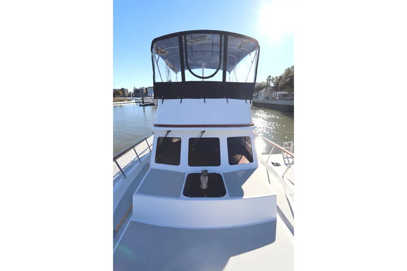 Slide: The Image of 2005 Monk 36 boat docked, featuring a spacious deck and enclosed flybridge. - 12