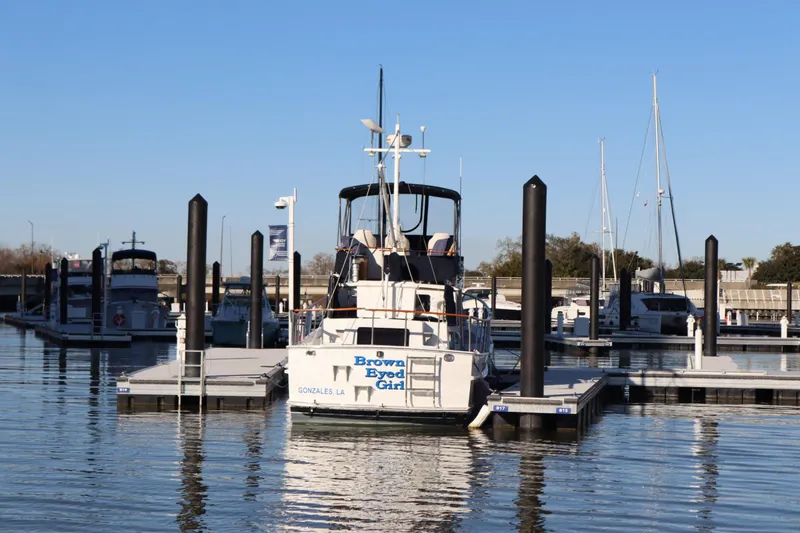 Slide: The Image of A 2005 Monk 36 boat docked at a marina under a clear blue sky. - 2