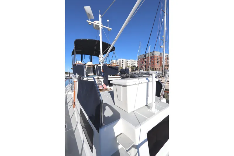 Slide: The Image of 2005 Monk 36 boat deck with canopy, docked in marina under clear blue sky. - 21