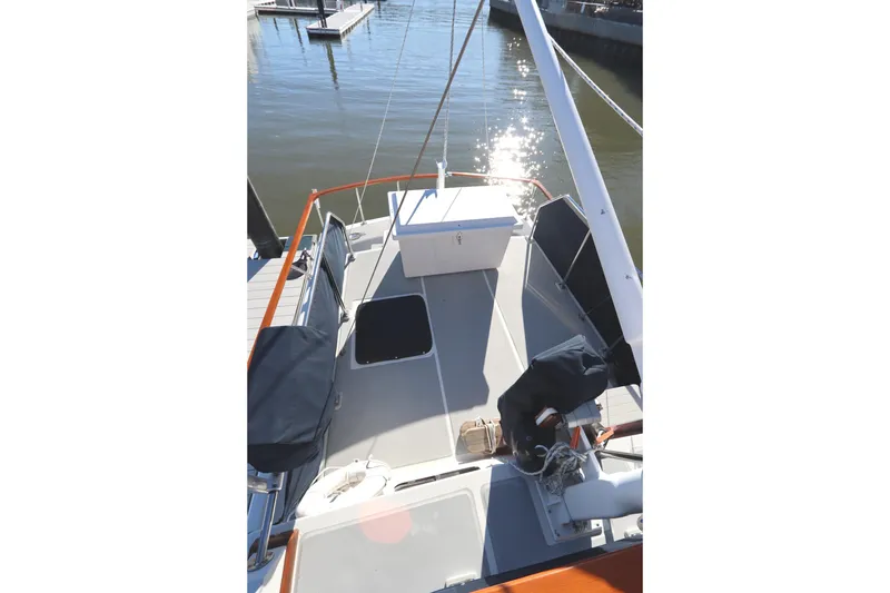 Slide: The Image of 2005 Monk 36 boat deck with seating and storage, docked by calm water. - 23