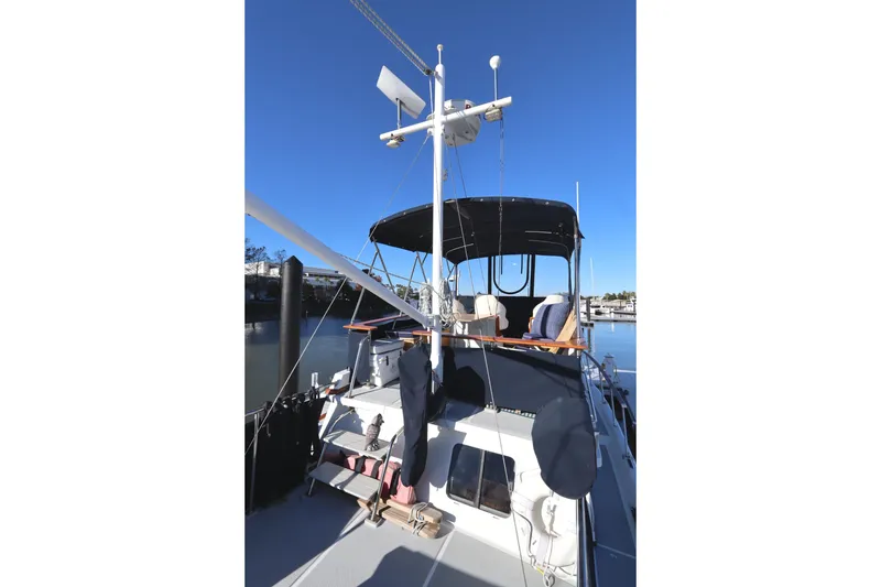 Slide: The Image of 2005 Monk 36 yacht docked, featuring a covered deck and clear blue sky. - 25