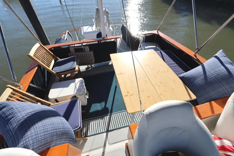 Slide: The Image of Spacious deck of 2005 Monk 36 boat with wooden table and cushioned seating. - 29
