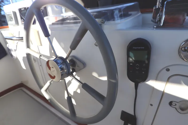 Slide: The Image of Steering wheel and controls of a 2005 Monk 36 boat cockpit. - 34