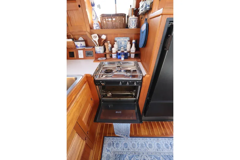 Slide: The Image of Compact kitchen in 2005 Monk 36 boat with stove, wooden cabinetry, and nautical decor. - 38