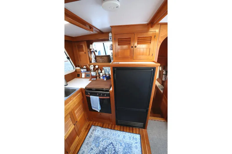 Slide: The Image of Interior of 2005 Monk 36 boat galley with wooden cabinetry and appliances. - 45