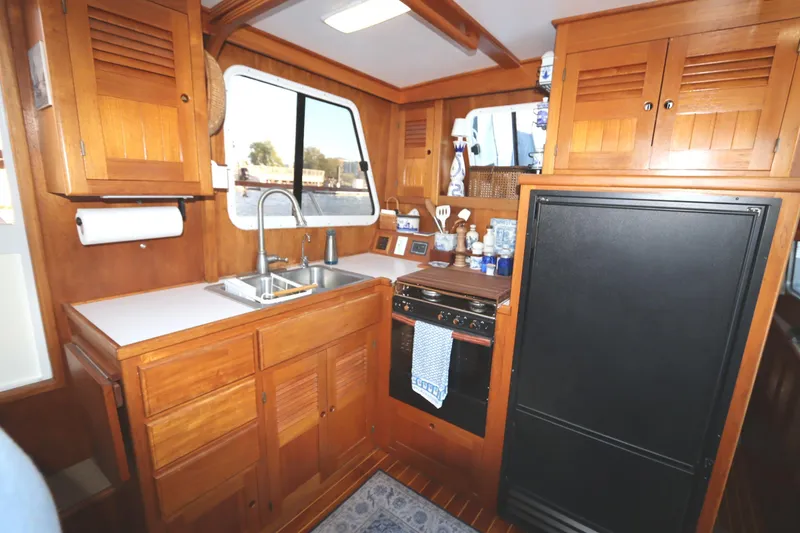 Slide: The Image of Wooden boat kitchen interior with sink, stove, and cabinets, Monk 36, 2005 model. - 48