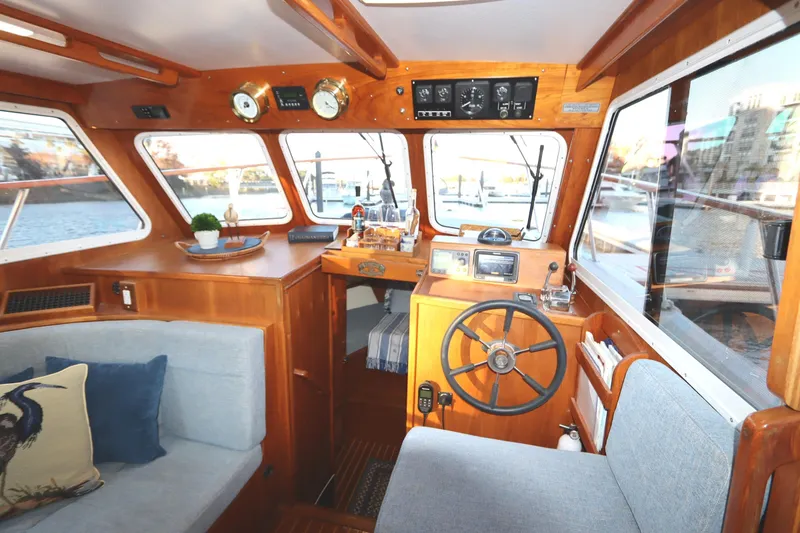 Slide: The Image of Interior of a 2005 Monk 36 boat with wooden helm and cozy seating. - 49