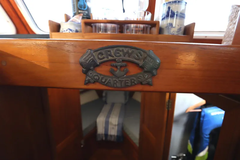 Slide: The Image of Monk 36 boat interior, 2005 model, featuring a 'Crew's Quarters' sign and cozy cabin. - 54