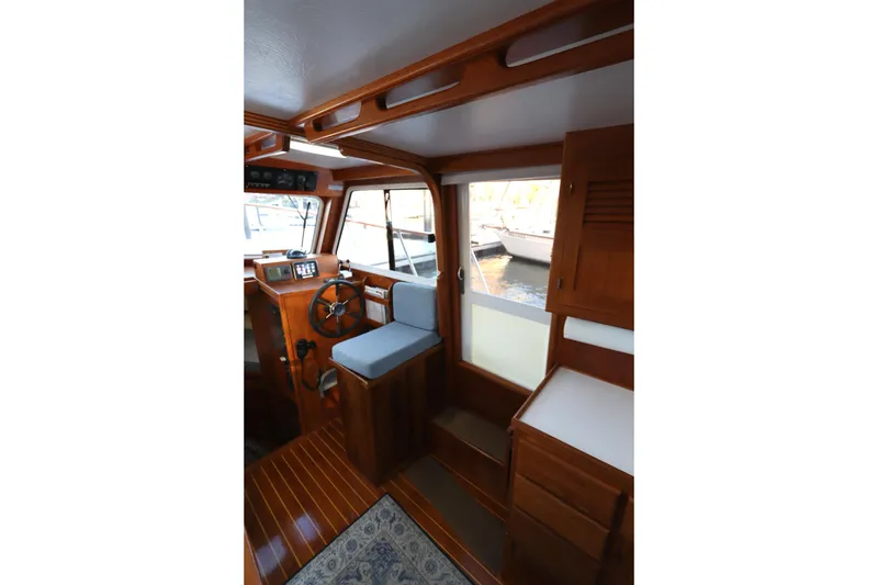 Slide: The Image of Interior of 2005 Monk 36 boat with wooden helm and seating area. - 66