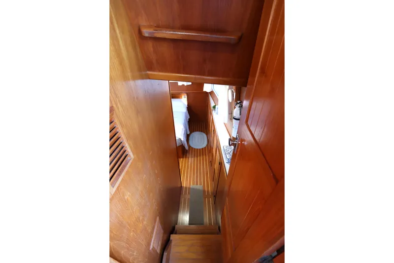 Slide: The Image of Interior view of 2005 Monk 36 boat, featuring wooden stairs and cozy cabin space. - 68