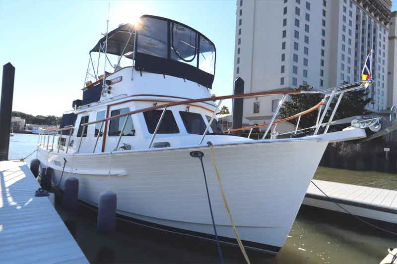 Slide: The Image of 2005 Monk 36 yacht docked at marina with cityscape background. - 7