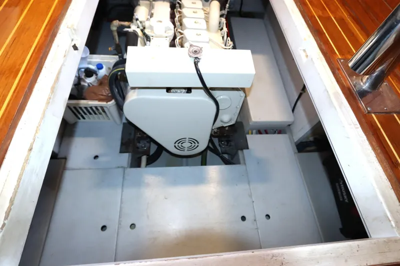 Slide: The Image of Engine compartment of a 2005 Monk 36 boat, showcasing machinery and wooden flooring. - 81