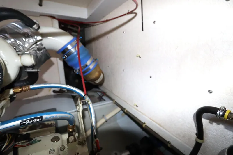 Slide: The Image of Engine compartment of a 2005 Monk 36 boat, featuring pipes and hoses. - 87