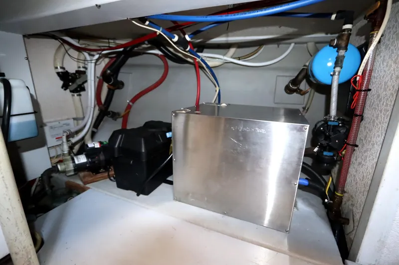 Slide: The Image of Engine compartment of a 2005 Monk 36 boat, featuring various mechanical components and wiring. - 90