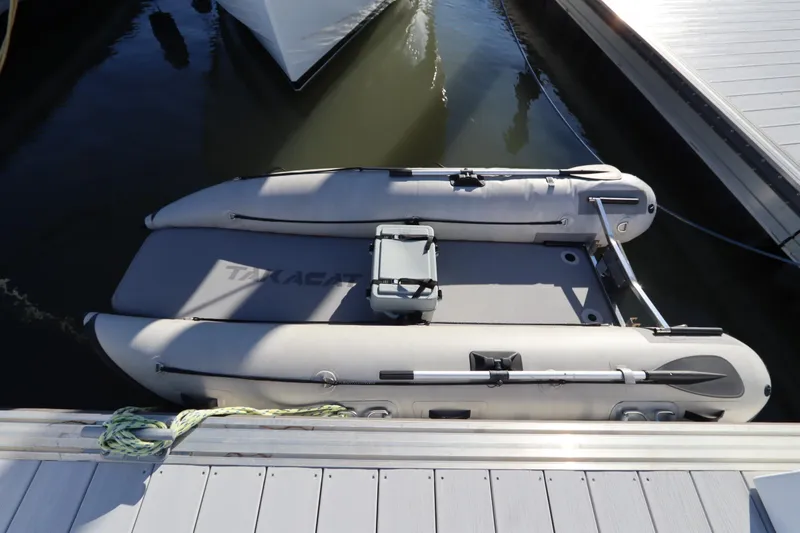 Slide: The Image of Inflatable boat docked at marina, featuring paddles and storage box, Monk 36 model, 2005. - 91