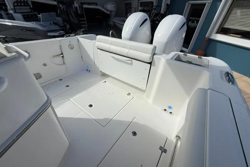 Slide: The Image of 2021 Edgewater 262CC boat interior with dual engines and seating area. - 12