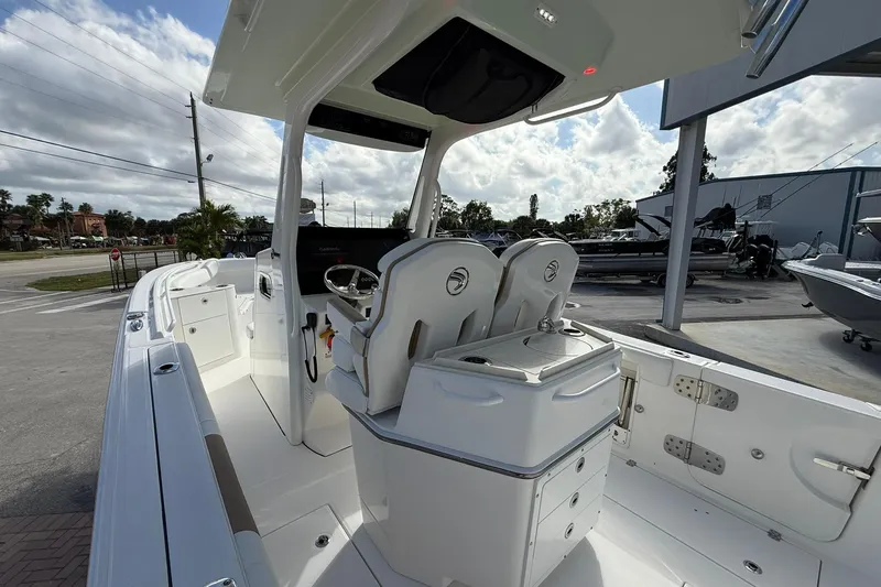 Slide: The Image of 2021 Edgewater 262CC boat interior with dual seats and helm station under a canopy. - 14