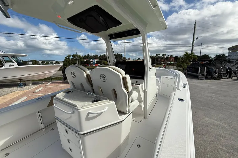 Slide: The Image of 2021 Edgewater 262CC boat interior with dual seats and console, under a partly cloudy sky. - 15