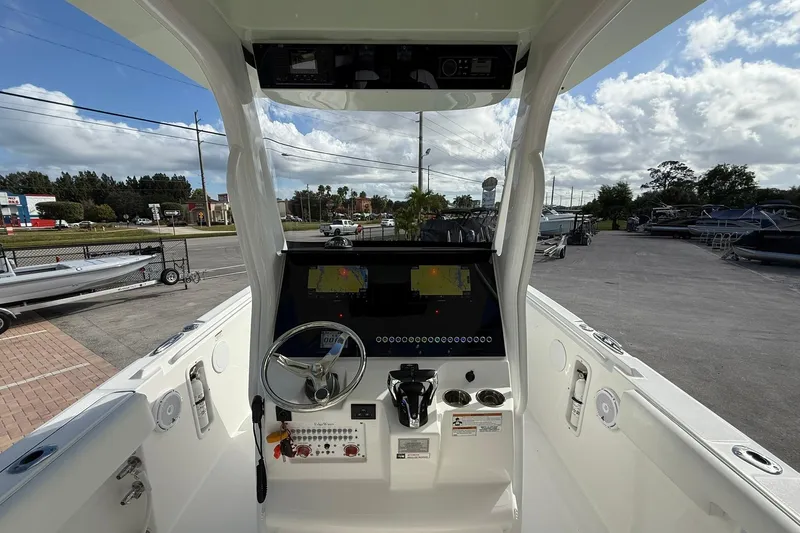 Slide: The Image of 2021 Edgewater 262CC boat console with steering wheel and navigation display. - 17