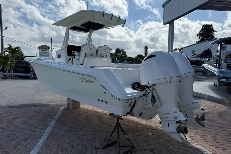 Slide: The Image of 2021 Edgewater 262CC boat with dual engines displayed outdoors on a sunny day. - 2