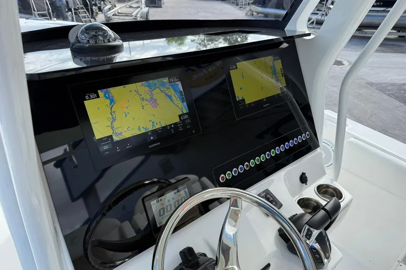 Slide: The Image of Edgewater 262CC 2021 boat dashboard with navigation screens and steering wheel. - 20