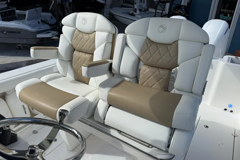 Slide: The Image of 2021 Edgewater 262CC boat seats with beige and white leather upholstery. - 21
