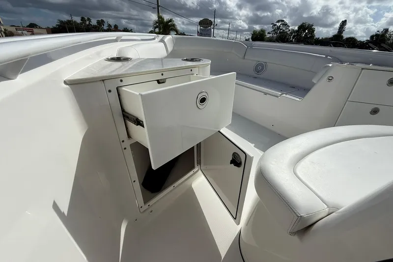 Slide: The Image of 2021 Edgewater 262CC boat interior with open storage compartment and seating. - 24