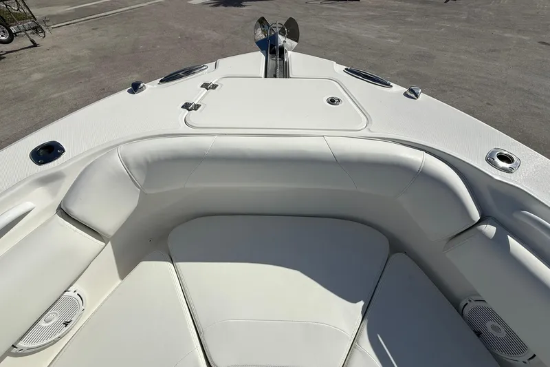 Slide: The Image of 2021 Edgewater 262CC boat interior with white cushioned seating and storage compartments. - 30