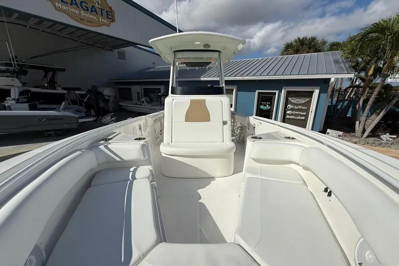 Slide: The Image of 2021 Edgewater 262CC boat interior with seating, displayed at a marine sales location. - 32
